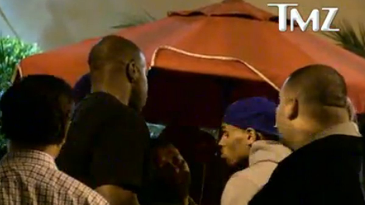 Chris Brown och hans livvakter ringar in parkeringsvakten i ett hörn. 